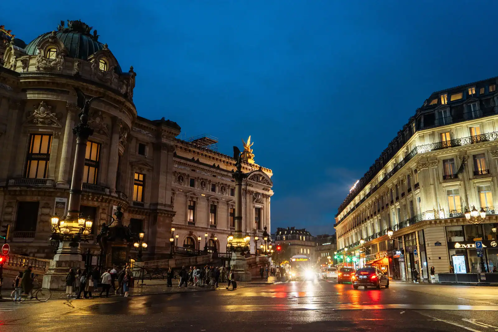 Opéra Garnier in Paris at night with illuminated façade and wet street